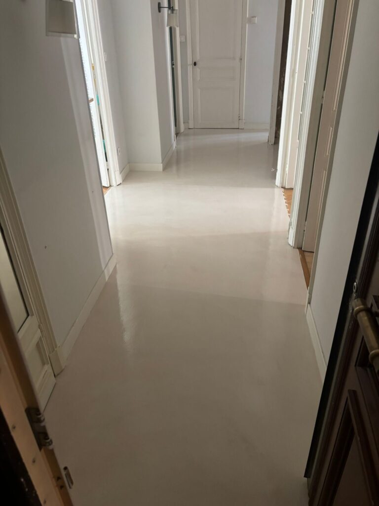 Détail texture béton ciré teinte claire Libération Nice 2026